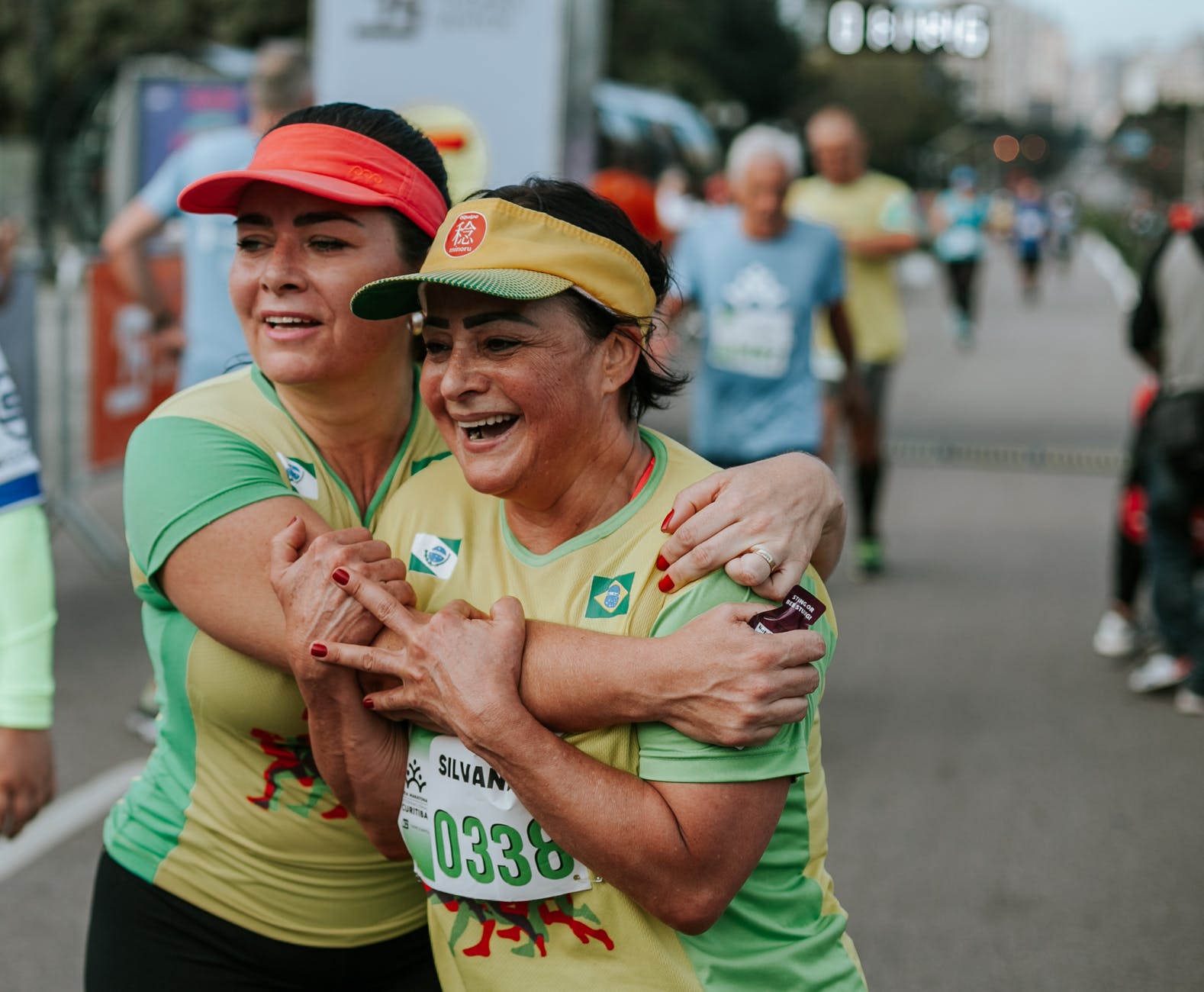 two smiling women wearing yellow and green shirts