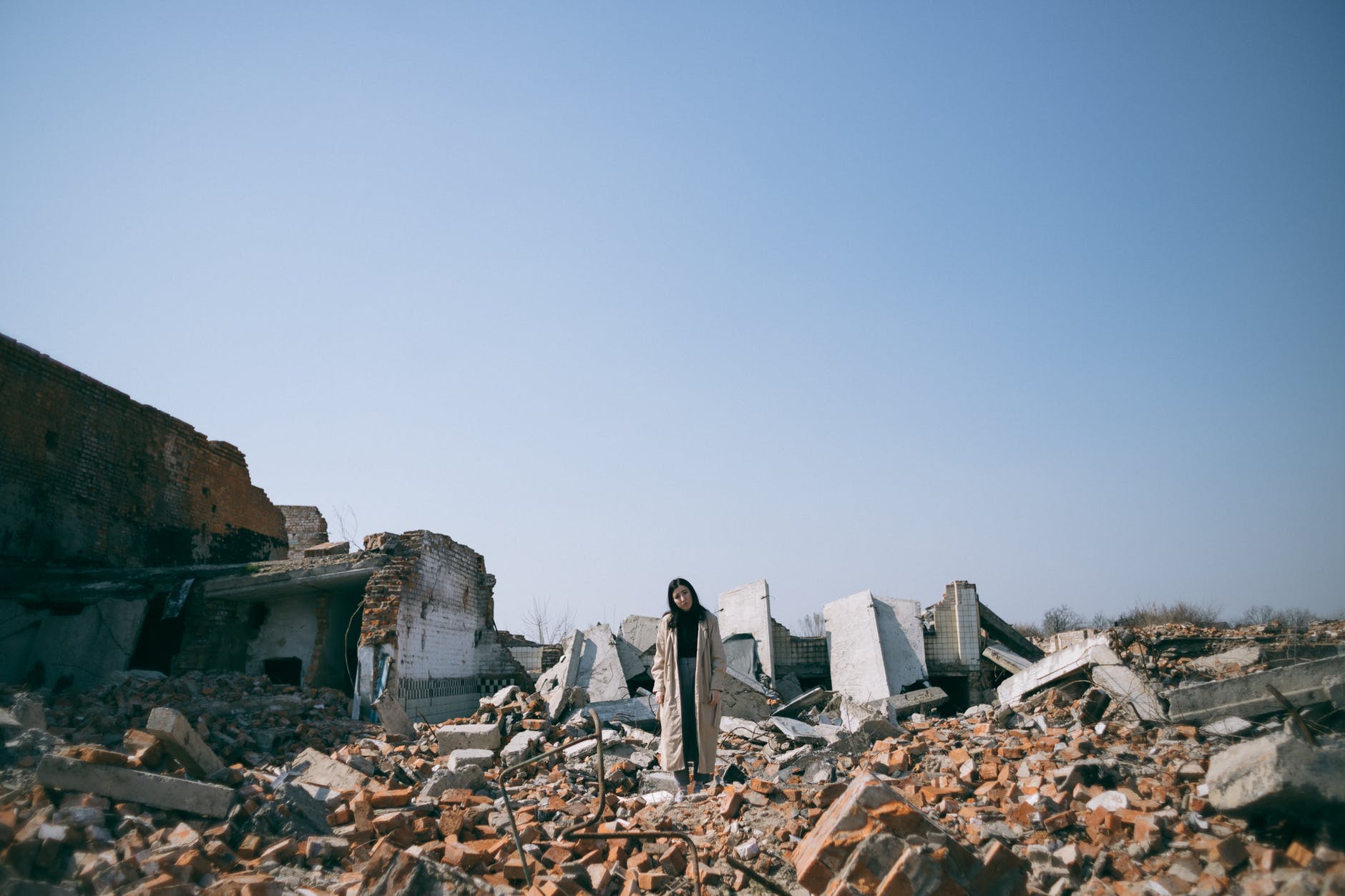 woman standing on ruins of a building